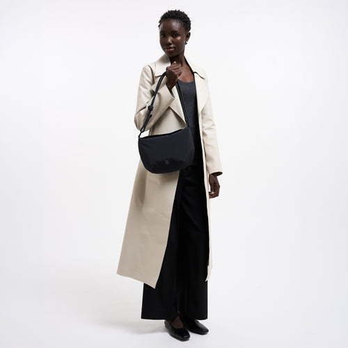 CLAM BAG Tasche in black (Schwarz) von einer Frau in der Hand gehalten.