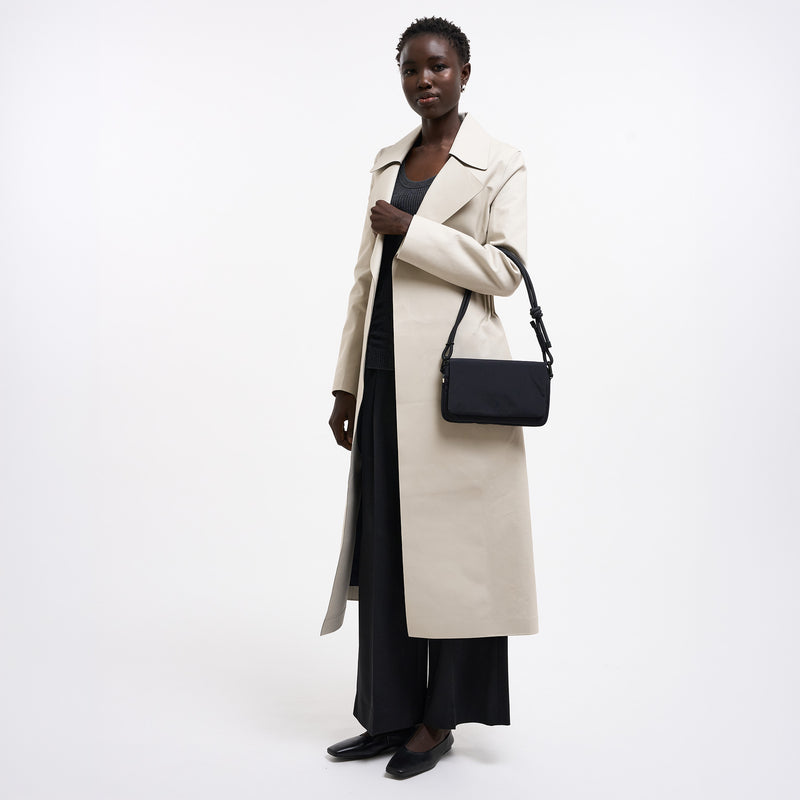 FACET BAG Tasche in black (Schwarz) von einer Frau über der Schulter getragen.