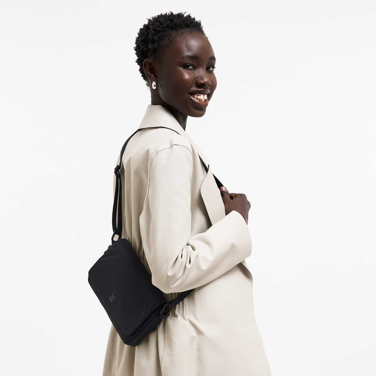 FACET BAG Tasche in black (Schwarz) von einer Frau crossbody getragen.