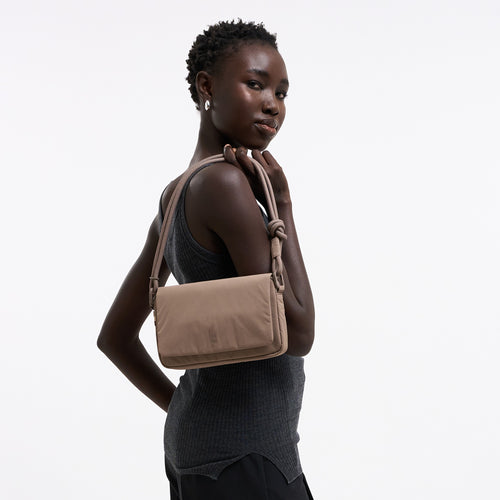 FACET BAG Tasche in oyster (klassisches Taupe-Braun) von einer Frau über der Schulter getragen.