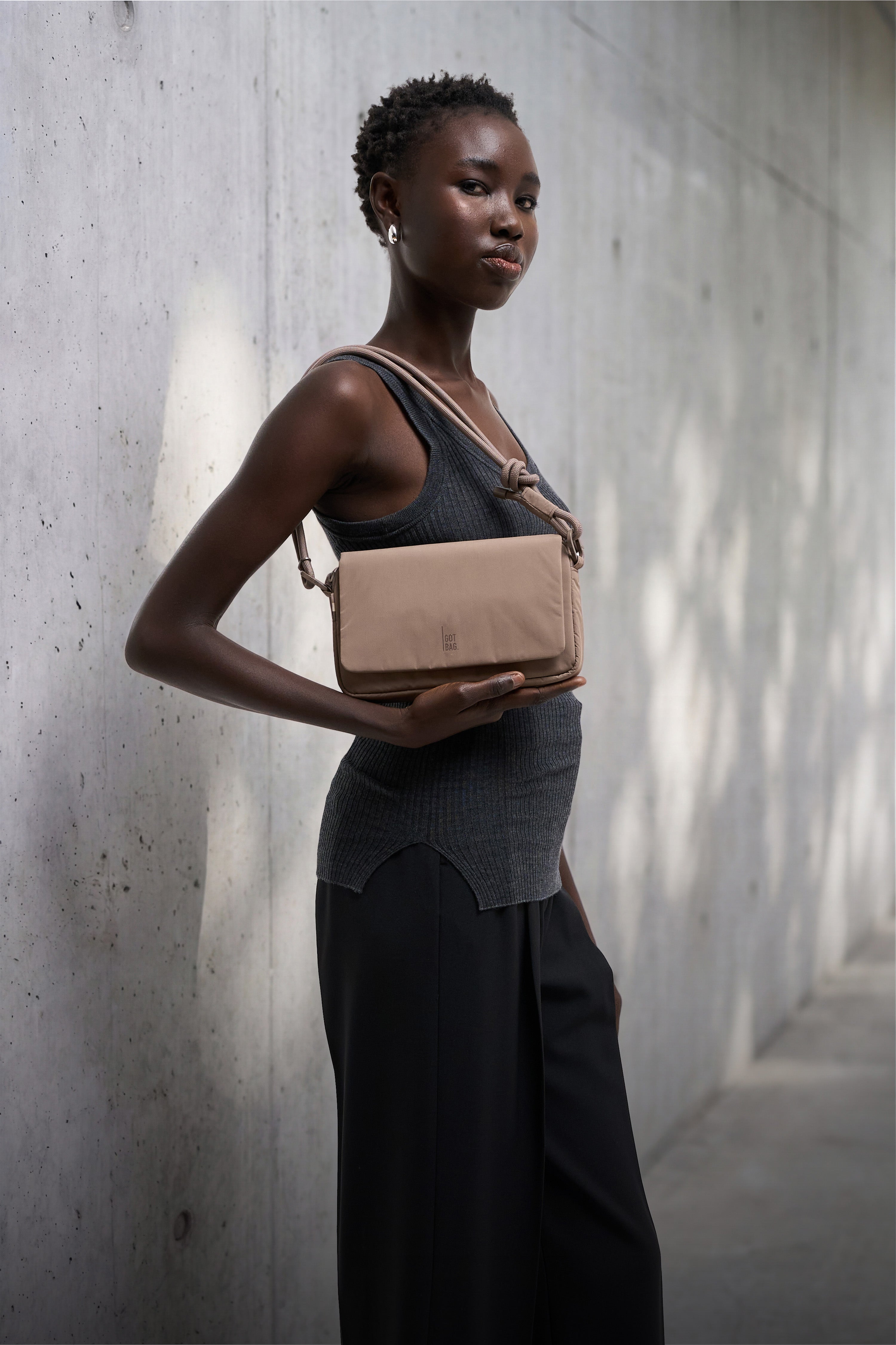FACET BAG bag in oyster (classic taupe-brown) worn crossbody by a woman.