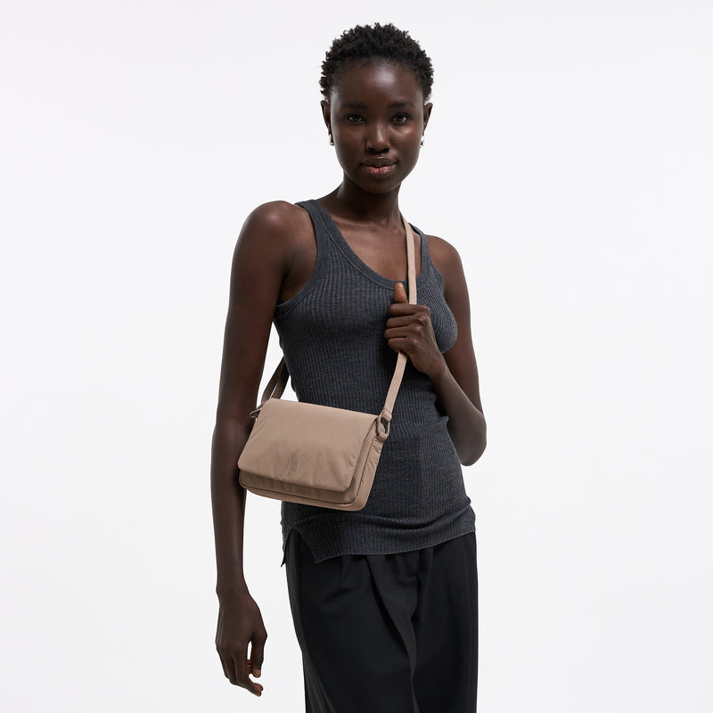 FACET BAG Tasche in oyster (klassisches Taupe-Braun) von einer Frau crossbody getragen.