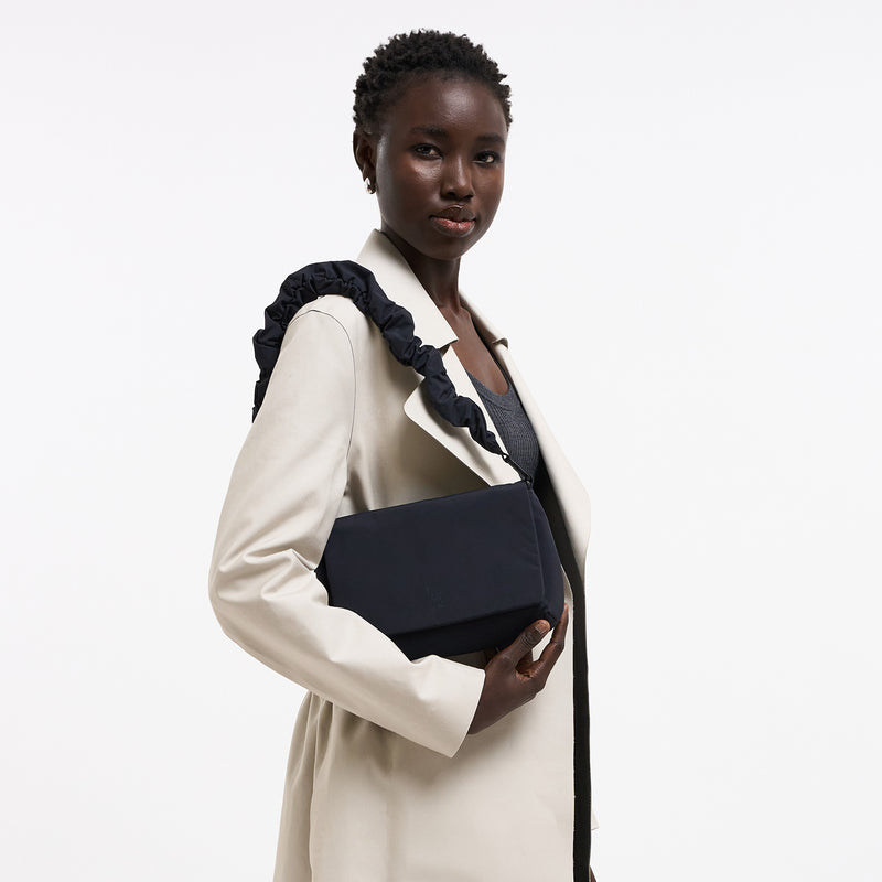 LUCID BAG Tasche in black (Schwarz) von einer Frau über der Schulter getragen.