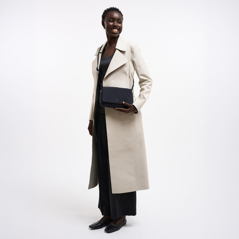 LUCID BAG Tasche in black (Schwarz) von einer Frau crossbody getragen.