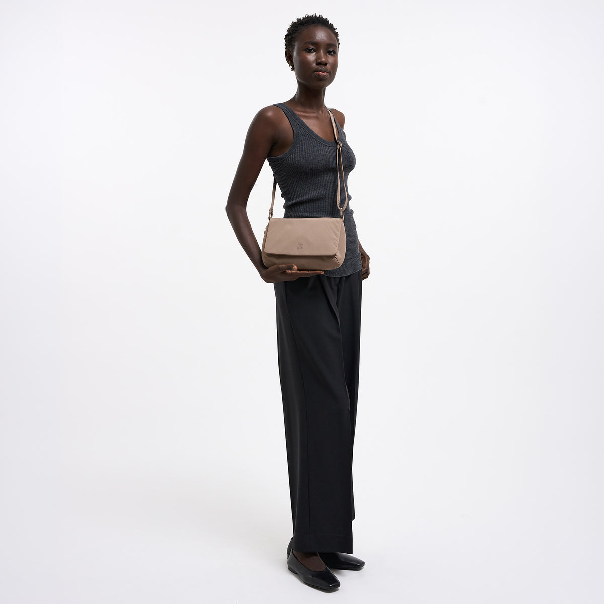 LUCID BAG Tasche in oyster (klassisches Taupe-Braun) von einer Frau crossbody getragen.