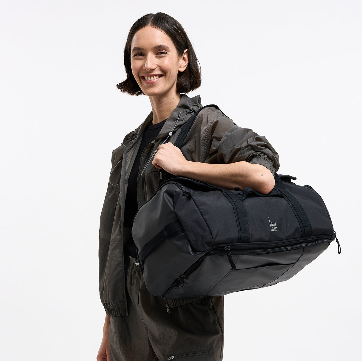 DUFFLE PACK Tasche in black (Schwarz) von einer Frau über der Schulter getragen.