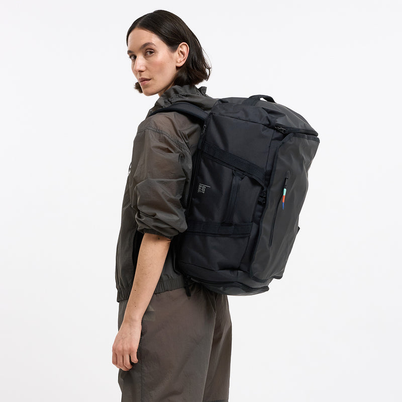 DUFFLE PACK Rucksack in black (Schwarz) von einer Frau auf dem Rücken getragen.