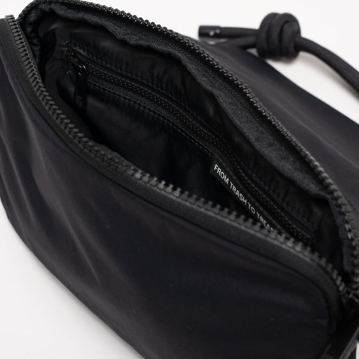 FACET BAG Tasche in black (Schwarz) geöffnet, zeigt Innenraum mit Label und Reißverschluss.