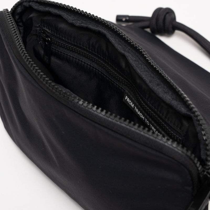 FACET BAG Tasche in black (Schwarz) geöffnet, zeigt Innenraum mit Label und Reißverschluss.