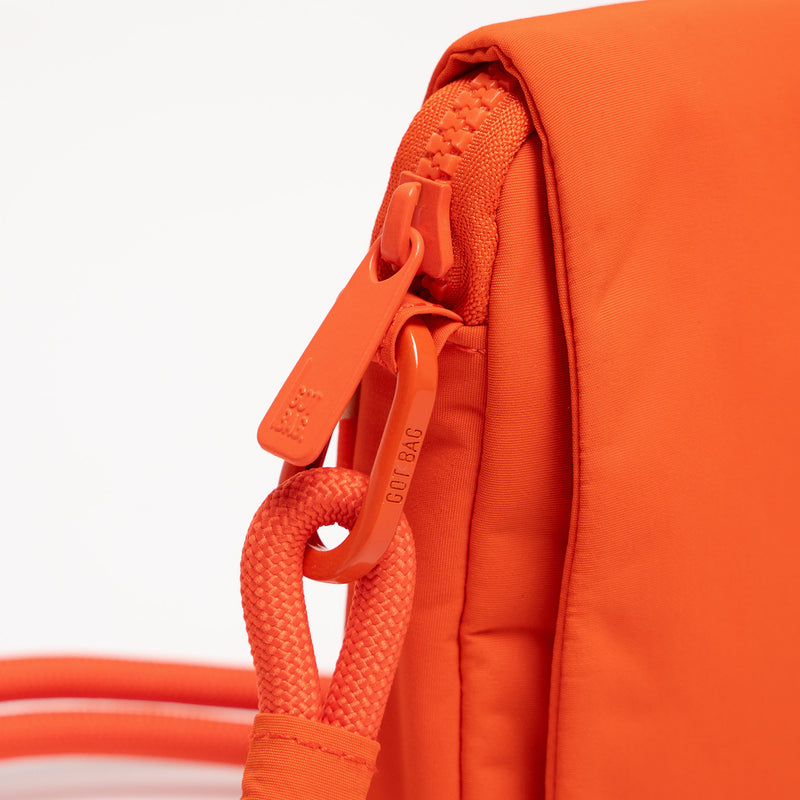 FACET BAG Tasche in hot coral (knalliges Orange), Detailaufnahme des Reißverschlusses und Karabiners.