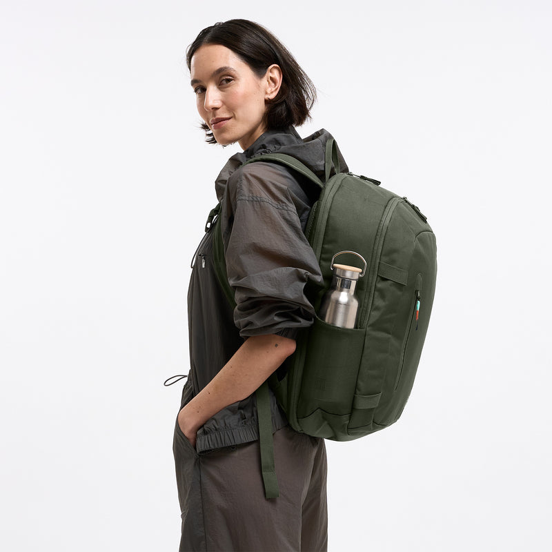 HYBRID PACK Rucksack in algae (Dunkelgrün mit Graustich) von einer Frau als Rucksack auf dem Rücken getragen.