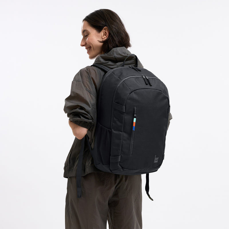 HYBRID PACK Rucksack in black (Schwarz) von einer Frau als Rucksack auf dem Rücken getragen.