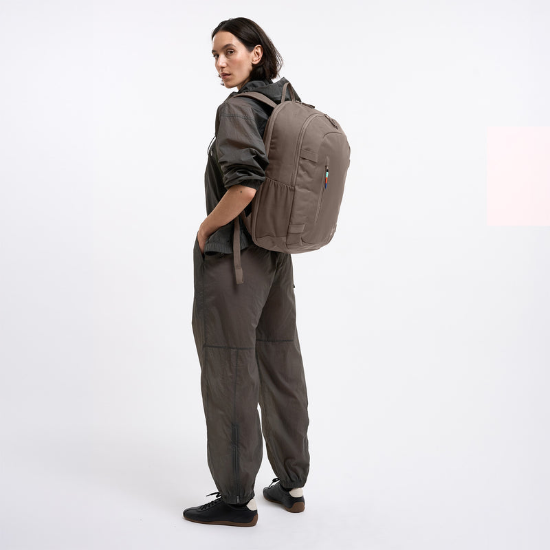 HYBRID PACK Rucksack in oyster (klassisches Taupe-Braun) von einer Frau als Rucksack auf dem Rücken getragen.