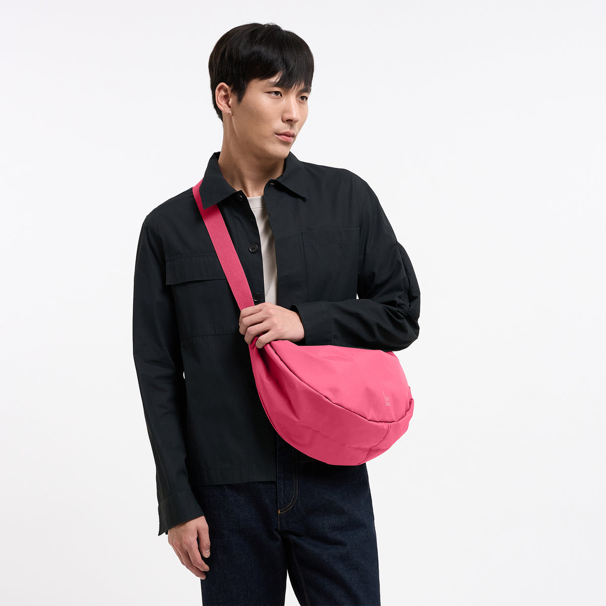 MOON BAG LARGE Tasche in salina pink (leuchtendes Pink) von einem Mann crossbody getragen.