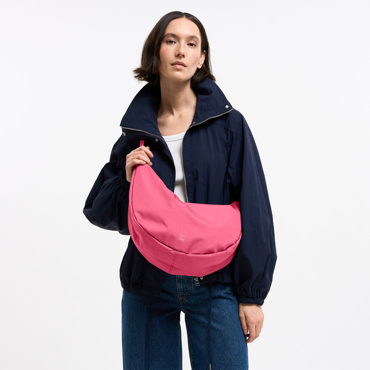 MOON BAG LARGE Tasche in salina pink (leuchtendes Pink) von einer Frau crossbody getragen.