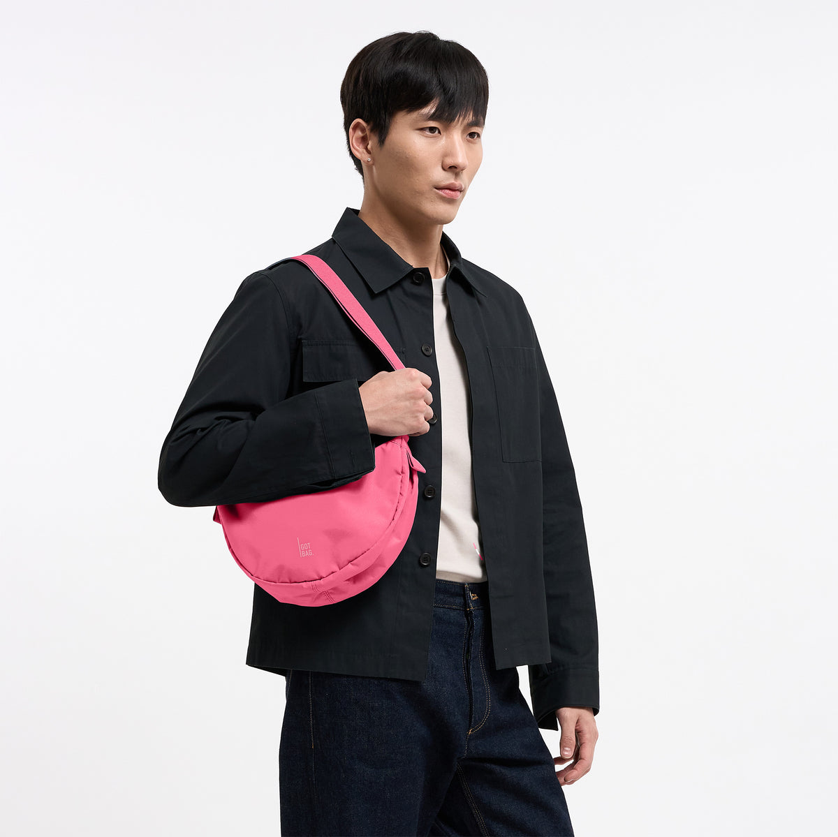 MOON BAG SMALL Tasche in salina pink (leuchtendes Pink) von einem Mann crossbody getragen.