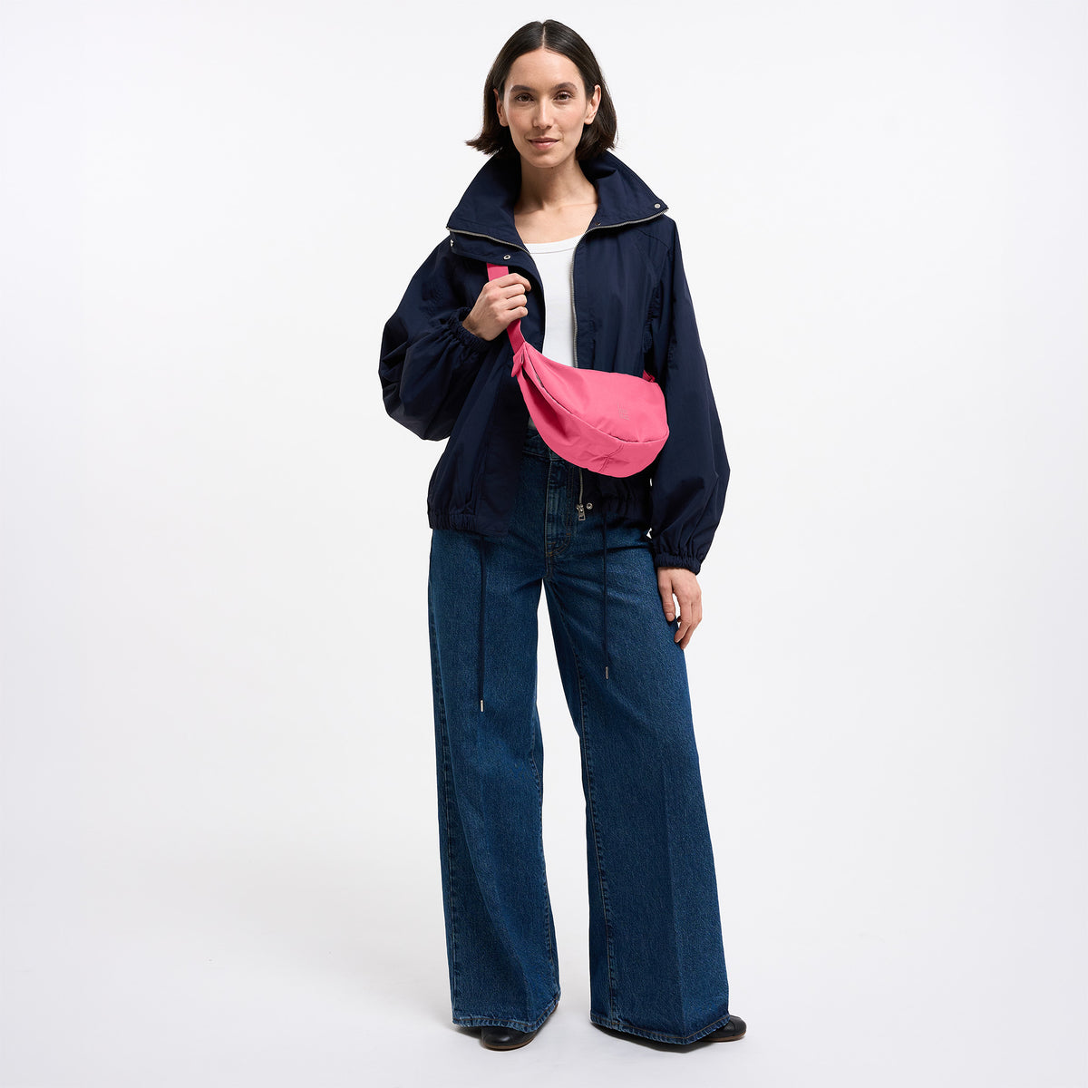 MOON BAG SMALL Tasche in salina pink (leuchtendes Pink) von einer Frau crossbody getragen.