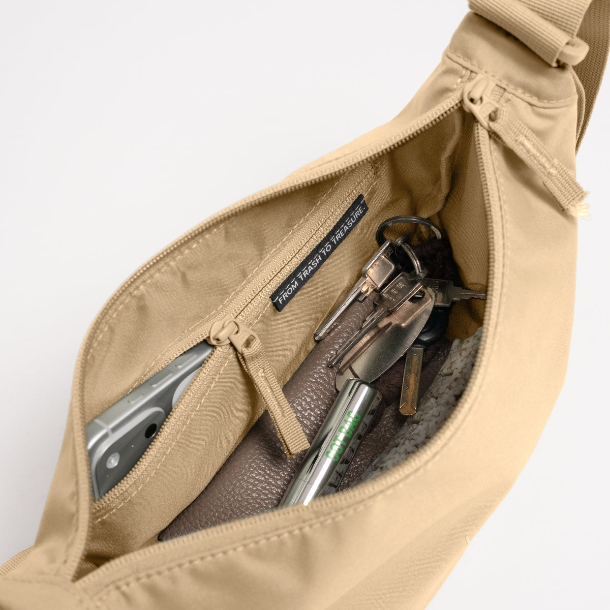 MOON BAG SMALL Tasche in sea moss (warmes Beige-Khaki), Innenansicht mit Handy und Schlüsseln.