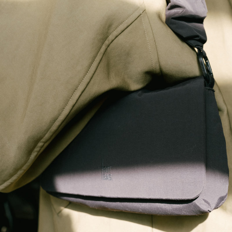 ESSENTIAL BAG bag carried over the shoulder by a person.