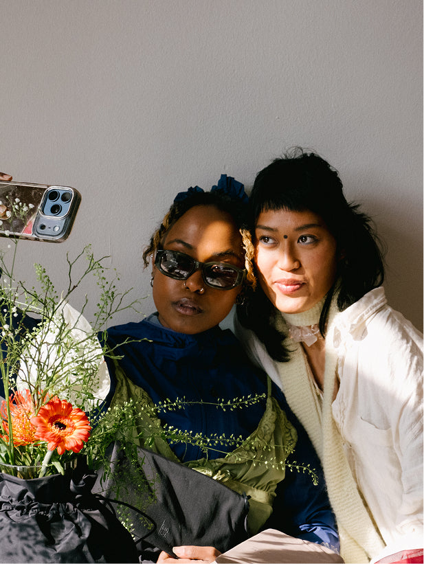 Bag held by a woman, with another woman next to her.