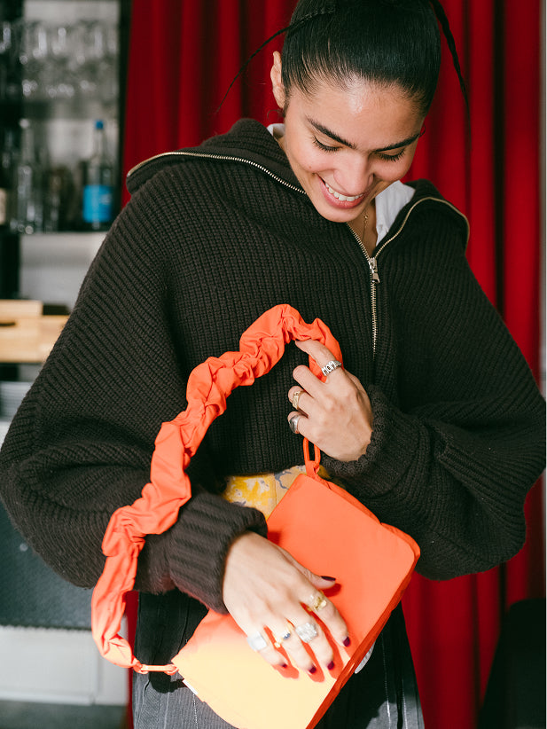 ESSENTIAL BAG bag held in the hand by a woman.
