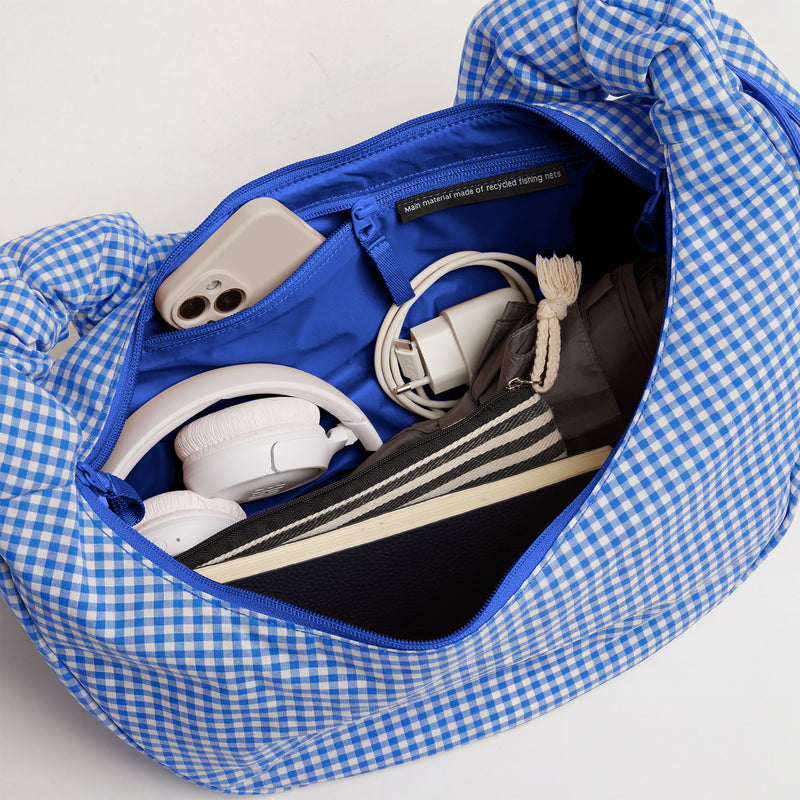 MOON BAG RUFFLE Tasche in vichy cobalt (blau-beige kariert), Innenansicht mit Handy, Kopfhörern und Ladekabel.