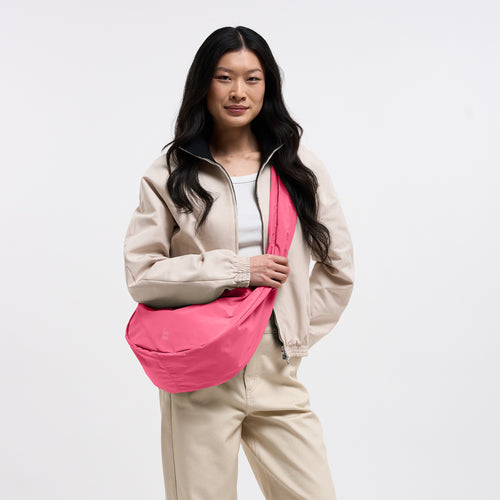 MOON BAG RUFFLE Tasche in salina pink (leuchtendes Pink) von einer Frau crossbody getragen.