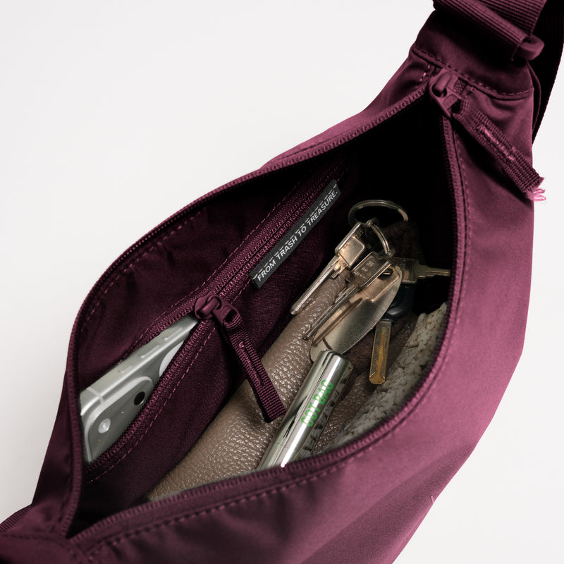 MOON BAG SMALL Tasche in kraken (Weinrot) Innenansicht mit Handy, Schlüsseln und dem Schriftzug FROM TRASH TO TREASURE.