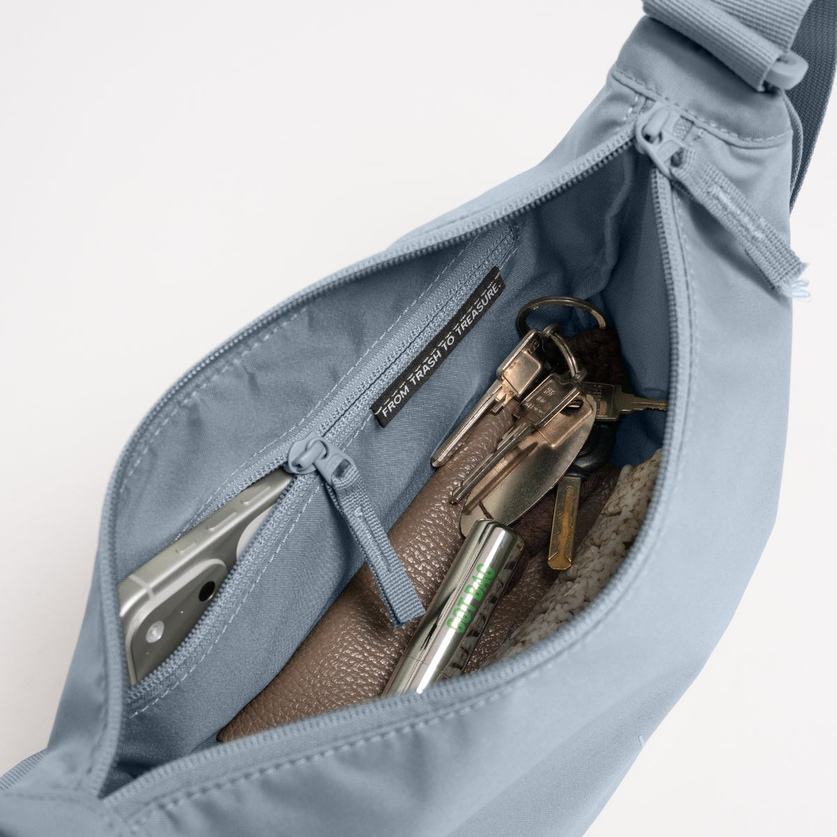 MOON BAG SMALL Tasche in marlin (grau-blau), Innenansicht mit Handy, Schlüsselbund, Label FROM TRASH TO TREASURE.