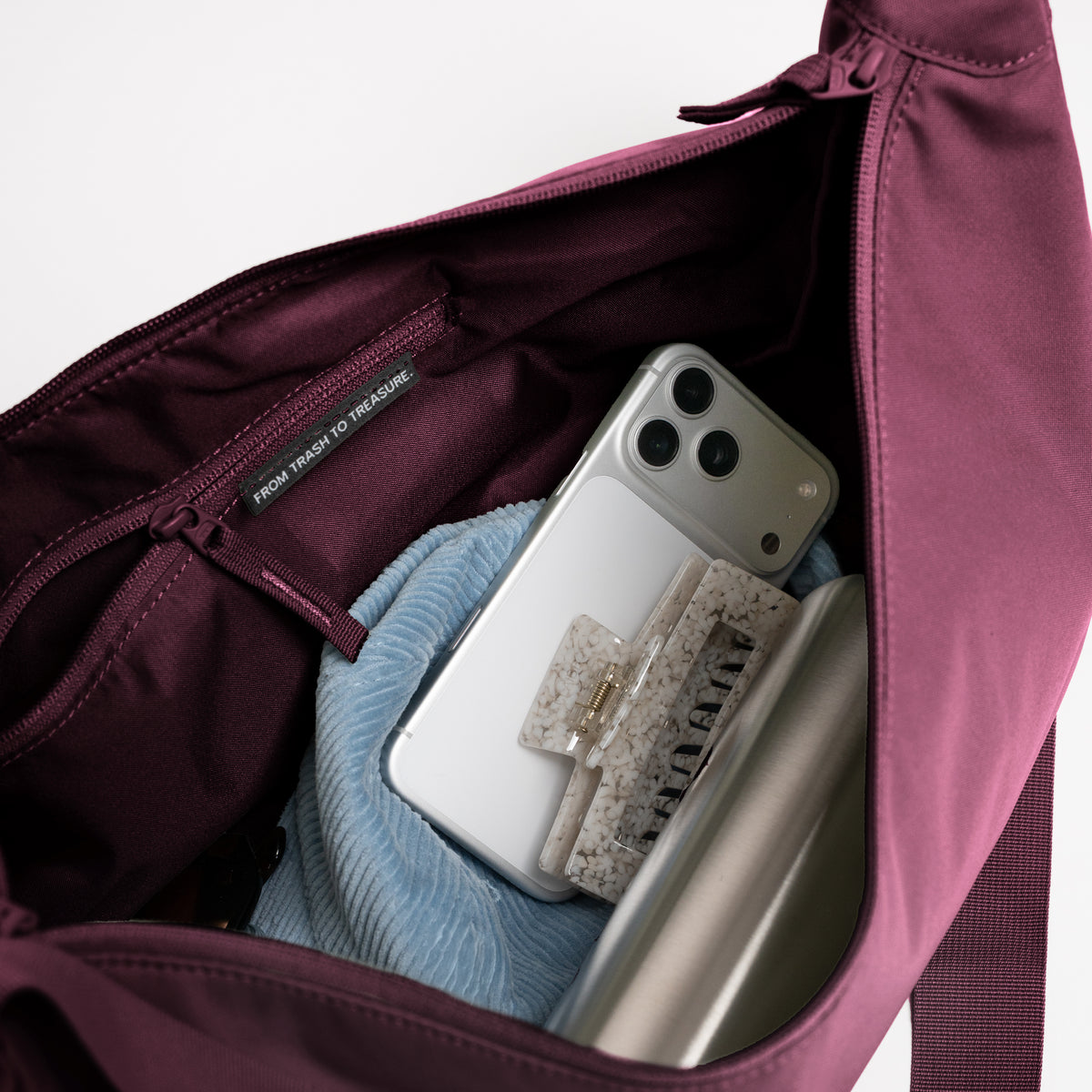 MOON BAG LARGE Tasche in kraken (Weinrot), Innenansicht mit Smartphone, Haarspange und Tag FROM TRASH TO TREASURE.