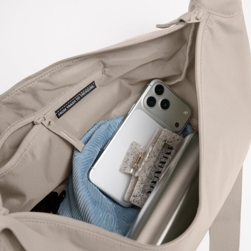 MOON BAG LARGE Tasche in scallop (helles Beige) als Innenansicht mit Handy und Haarklammer.