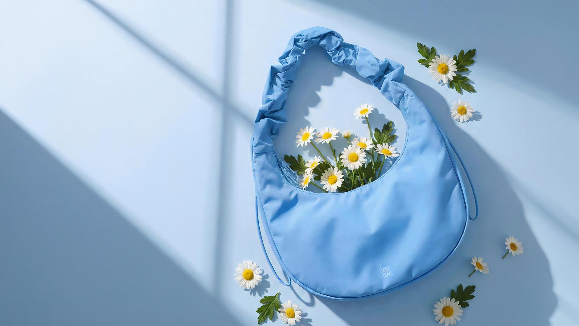 Tas met geplooide handgreep, gevuld met verse madeliefjes, op een bijpassende achtergrond met raamschaduwen.