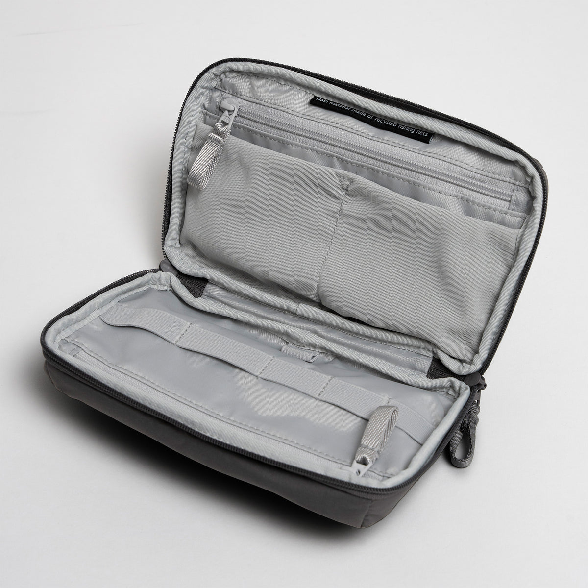 COMMUTER TECH POUCH Tasche in shark (Dunkelgrau), geöffnet mit Innenfächern.