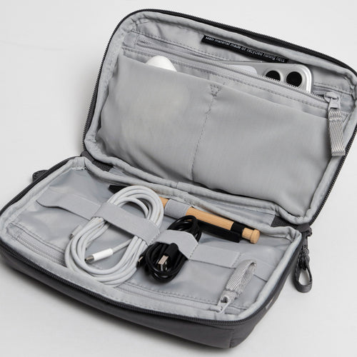 COMMUTER TECH POUCH Accessoires in shark (Dunkelgrau) geöffnet, zeigt Innenfächer und Zubehör.