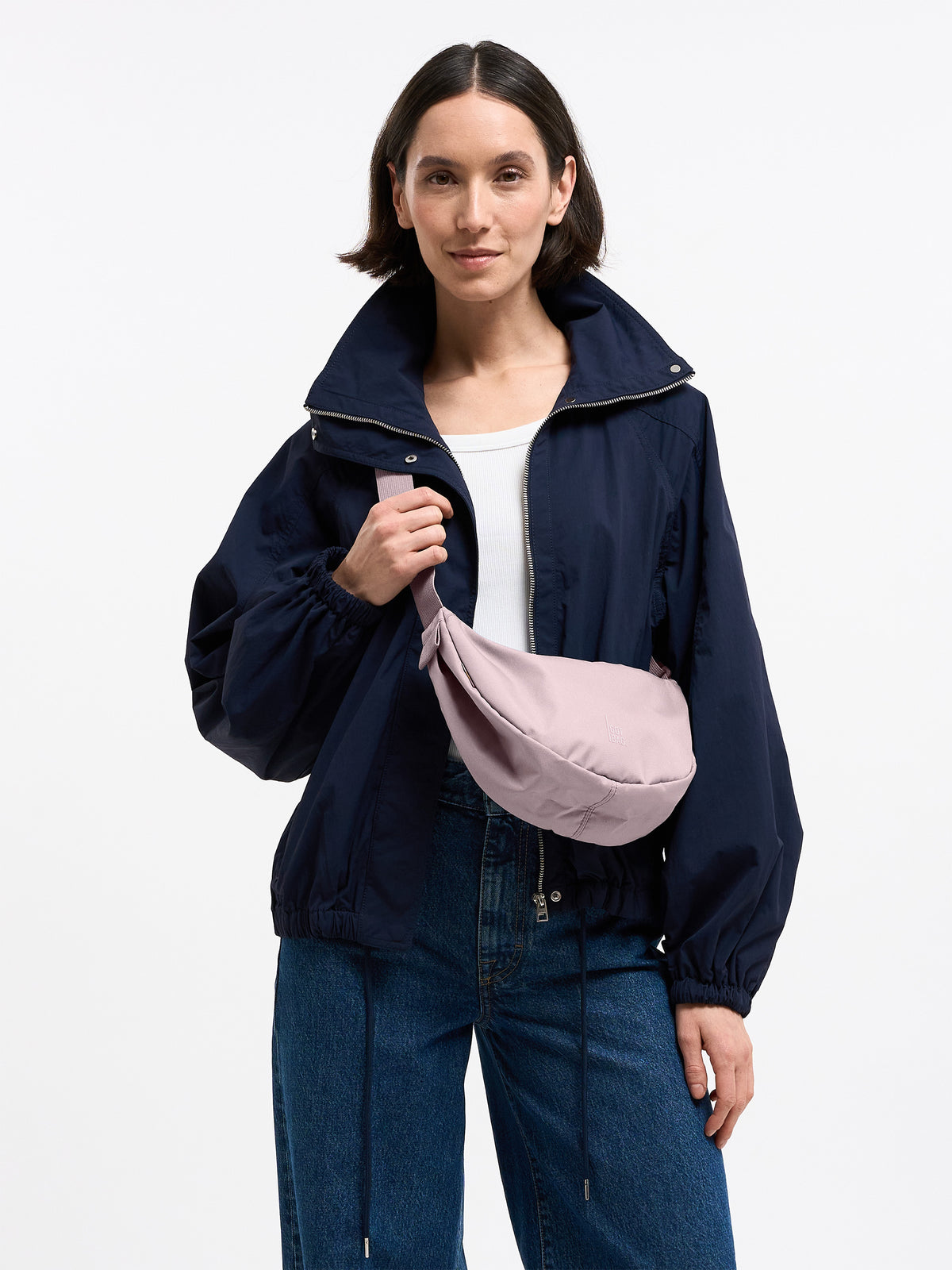 MOON BAG SMALL MONOCHROME Tasche in pink dolphin (blasses Hellrosa) von einer Frau crossbody getragen.
