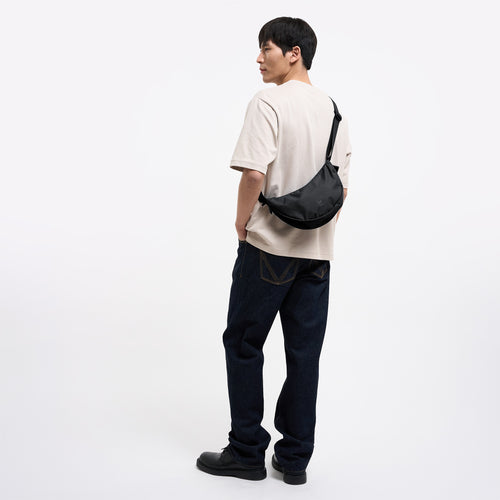 MOON BAG SMALL Tasche in black (Schwarz) von einem Mann crossbody getragen.