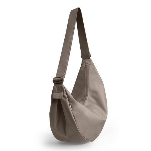 MOON BAG LARGE MONOCHROME Tasche in seal (dunkler Beigeton) als Studioaufnahme, diagonal hängend.