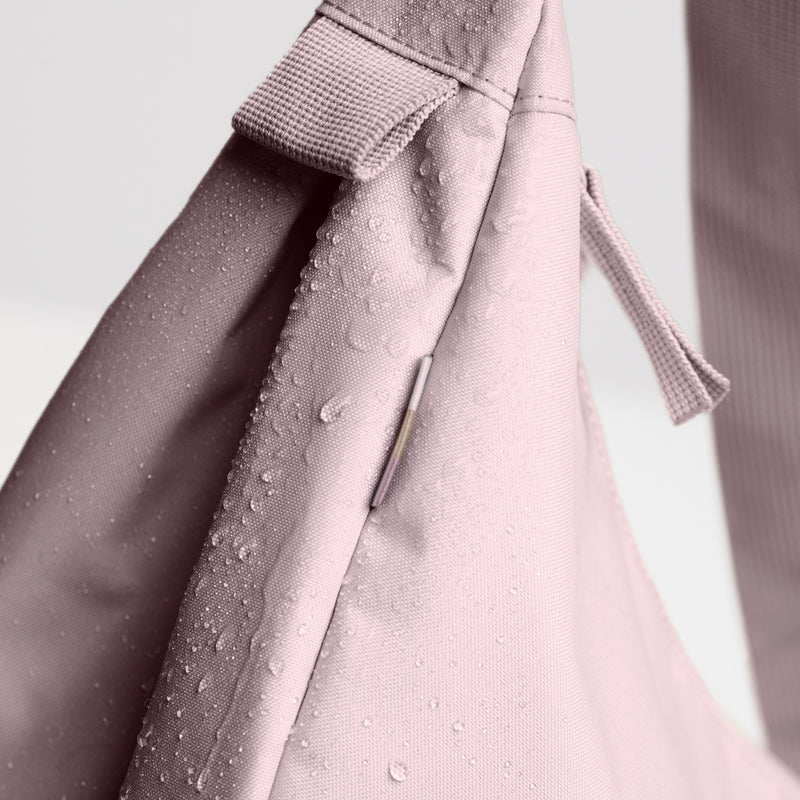 MOON BAG LARGE MONOCHROME Tasche in pink dolphin (blasses Hellrosa) mit Wassertropfen auf dem Material.