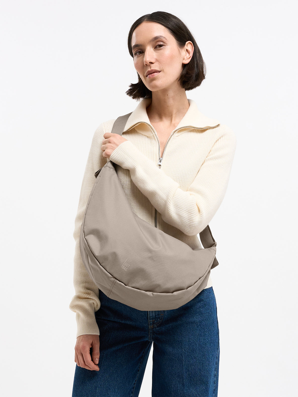 MOON BAG LARGE Tasche in scallop (helles Beige) von einer Frau crossbody getragen.
