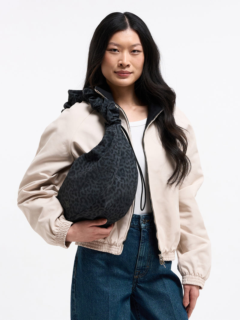 MOON BAG RUFFLE CATSHARK Tasche in black (Schwarz) von einer Frau über der Schulter getragen.