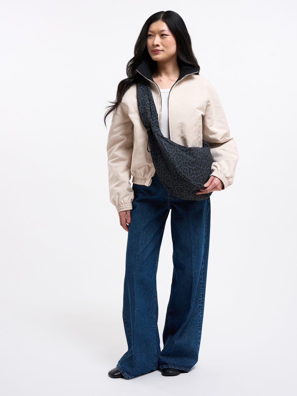 MOON BAG RUFFLE CATSHARK Tasche in black (Schwarz) von einer Frau crossbody getragen.