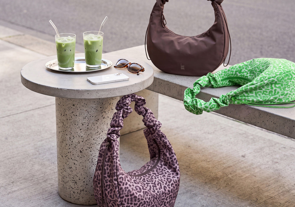 MOON BAG RUFFLE CAT SHARK Tasche in sea lion (dunkles Schokobraun) auf Betonbank.