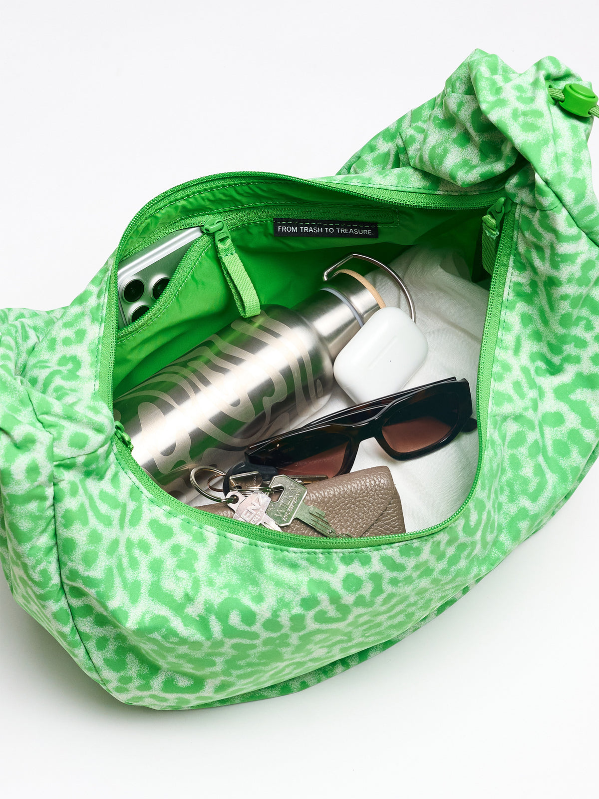 MOON BAG RUFFLE CAT SHARK Tasche, offene Innenansicht mit Smartphone, Wasserflasche, Kopfhörern, Sonnenbrille, Schlüsseln, Geldbörse.
