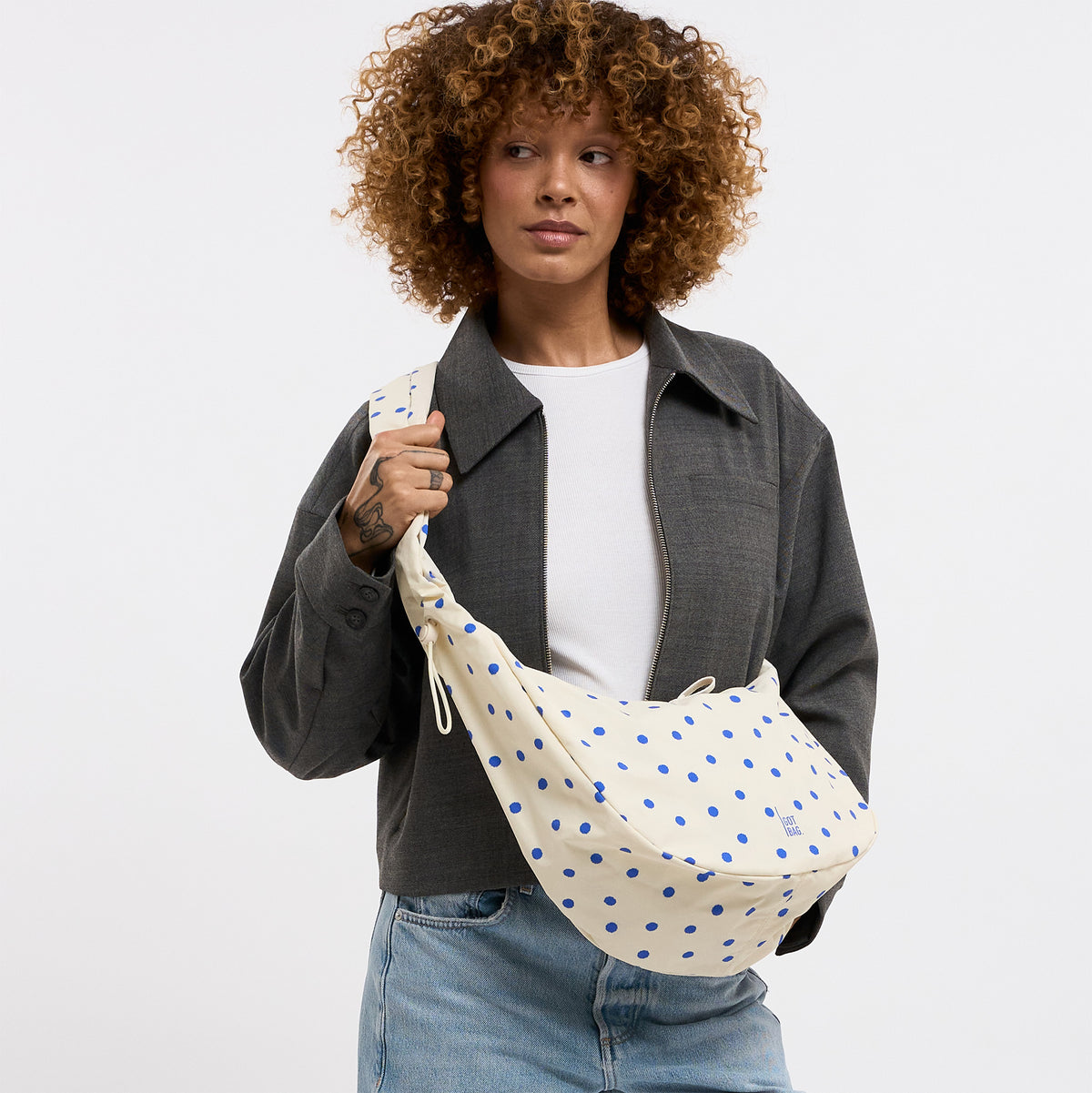 MOON BAG RUFFLE DOT Tasche in cream von einer Frau crossbody getragen.