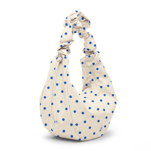 MOON BAG RUFFLE DOT Tasche in cream mit blauen Tupfen in diagonaler Ansicht.