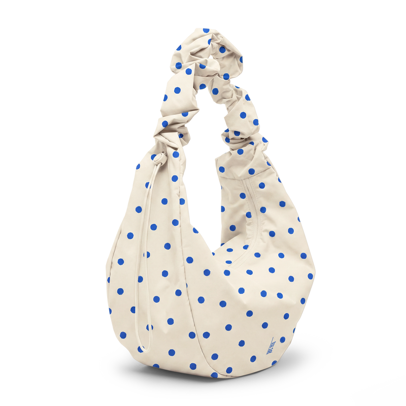 MOON BAG RUFFLE DOT Tasche in cream mit blauen Tupfen in diagonaler Ansicht.