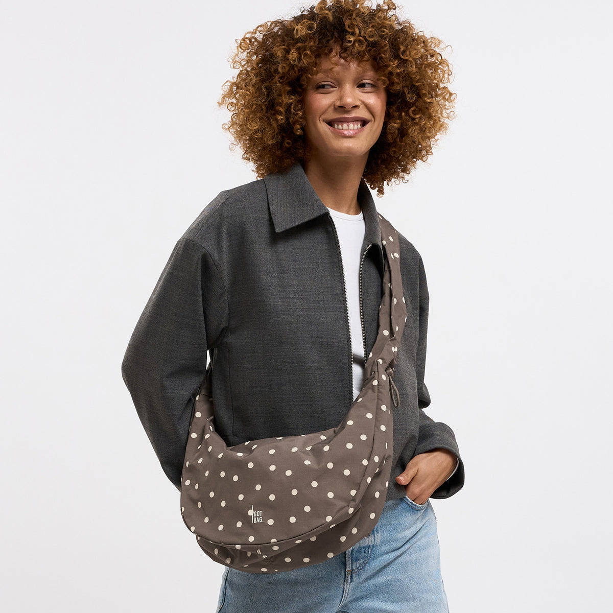 MOON BAG RUFFLE DOT Tasche in oyster (klassisches Taupe-Braun) von einer Frau crossbody getragen.