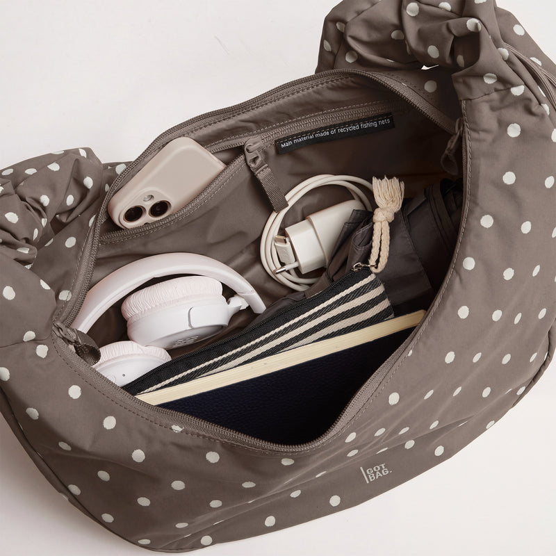 MOON BAG RUFFLE DOT Tasche in oyster (klassisches Taupe-Braun) mit Inhalt in der Innenansicht.