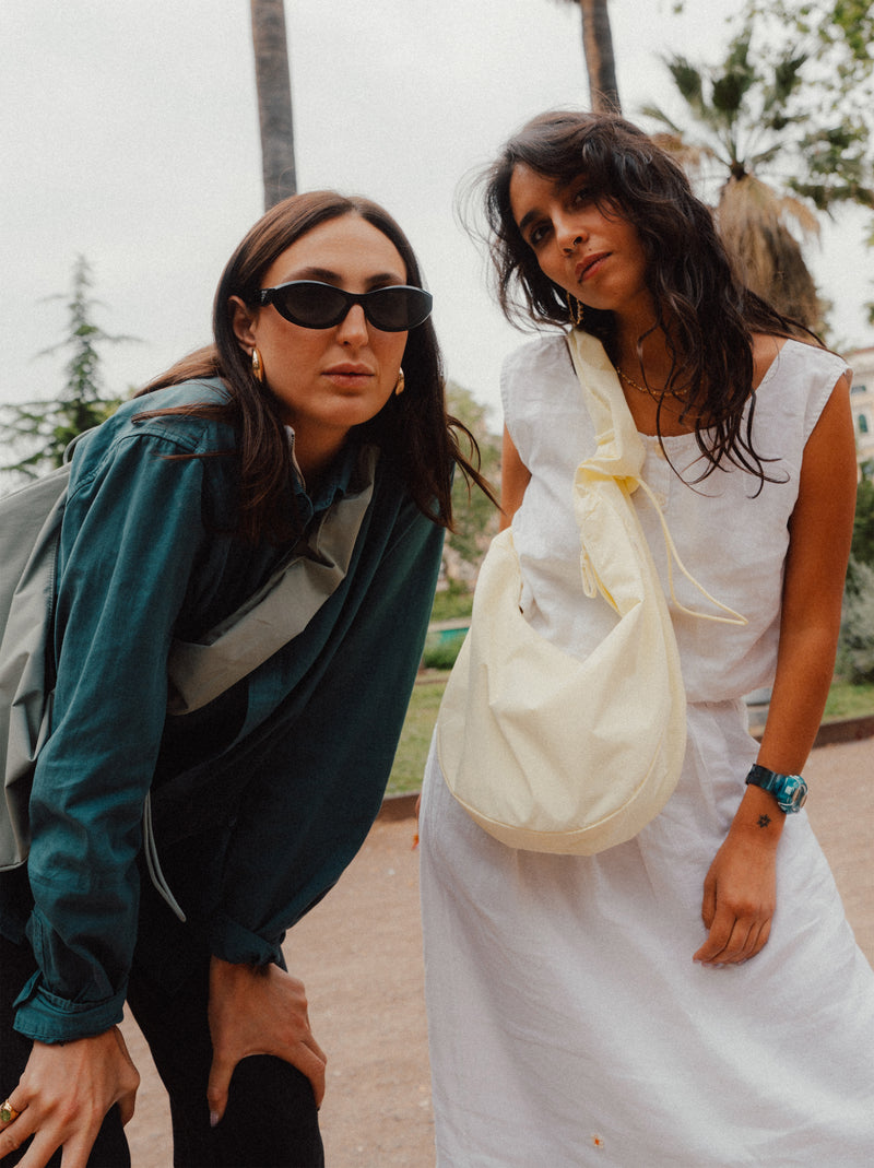 MOON BAG RUFFLE tas in sea lemon (zacht pastelgeel) crossbody gedragen door een vrouw.