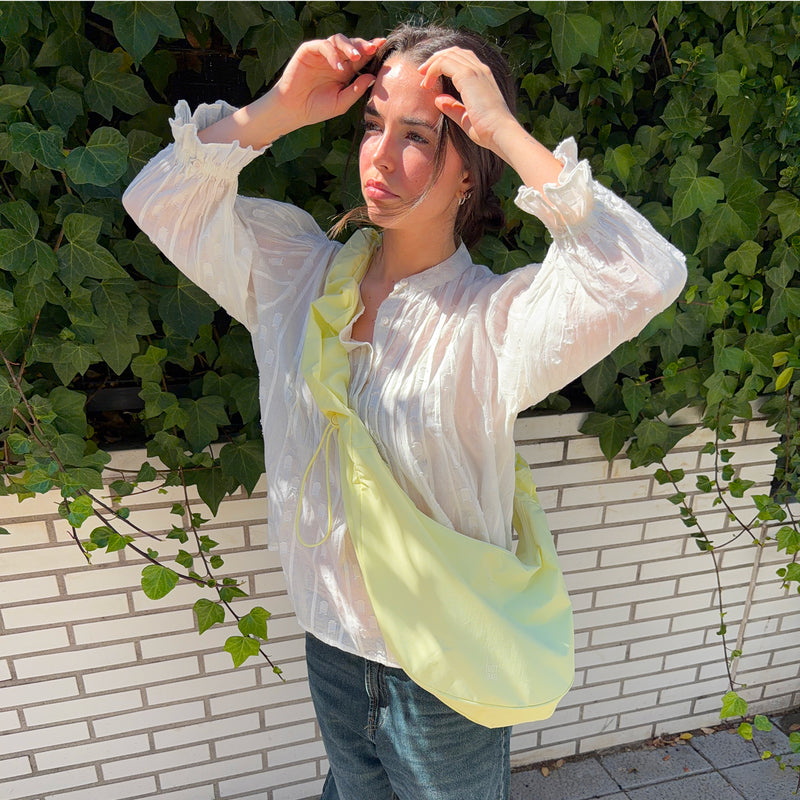 MOON BAG RUFFLE taška in sea lemon (jemná pastelově žlutá) nošena crossbody ženou.